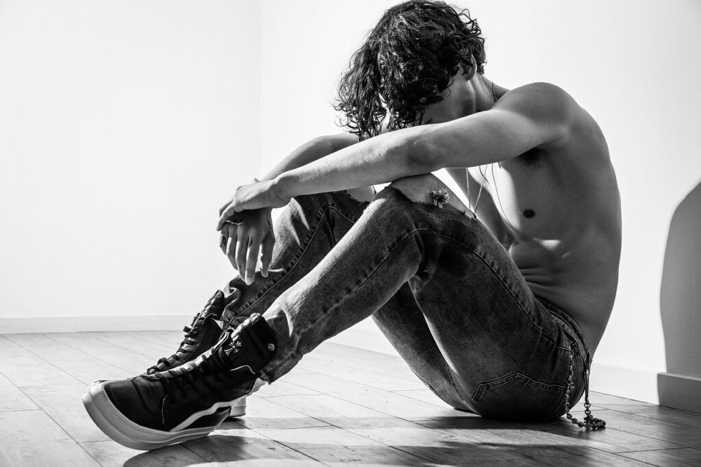 uomo con spalle al muro che sta riflettendo | Corpo e anima