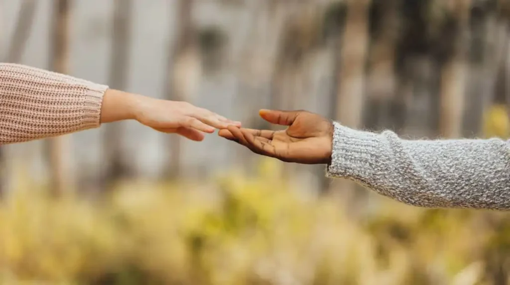 Braccia e mani che si allungano per toccarsi | Corpo e anima