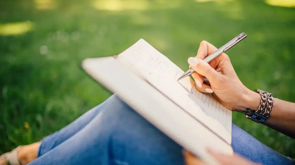 Un diario aperto con una mano che scrive | Corpo e anima