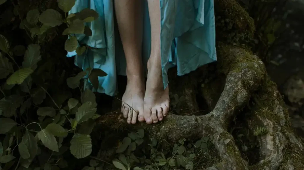 Radicamento spirituale: piedi che si radicano nella natura sulle radici di un albero | Corpo e anima