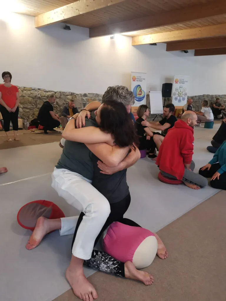 Un uomo e una donna si abbandonano in un abbraccio liberatorio durante l'Active Integrative Method TM | Tantra e amore